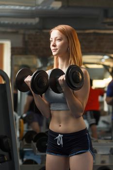 Concept: sport, healthy lifestyle. Young strong girl do exercises with dumbbells
