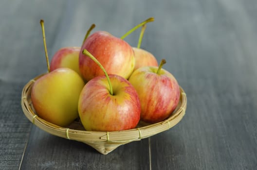 Red and yellow apple  with bamboo basket , organic fresh fruit on white  wooden background