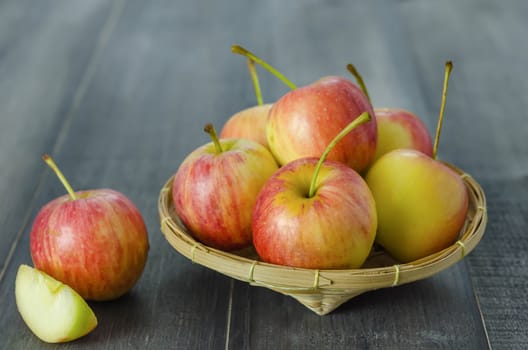 Red and yellow apple  with bamboo basket , organic fresh fruit on white  wooden background