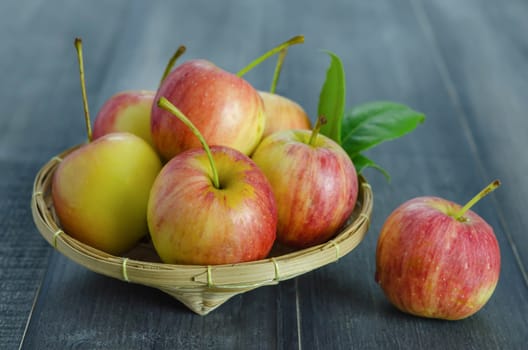 Red and yellow apple  with bamboo basket , organic fresh fruit on white  wooden background