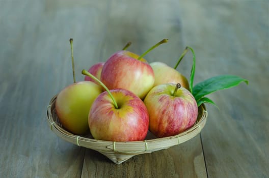 Red and yellow apple  with bamboo basket , organic fresh fruit on white  wooden background
