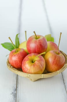 Red and yellow apple  with bamboo basket , organic fresh fruit on white  wooden background