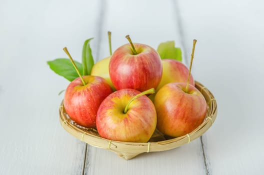 Red and yellow apple  with bamboo basket , organic fresh fruit on white  wooden background