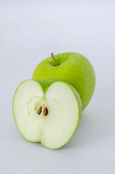 Ripe green apple and half  on a white background