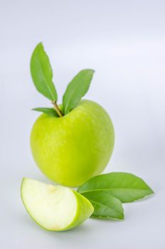 Ripe green apple with leaf and slice on a white background