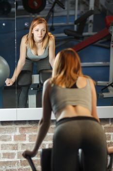 Concept: sport, healthy lifestyle. Young strong girl with nice booty do exercises for abs in gym