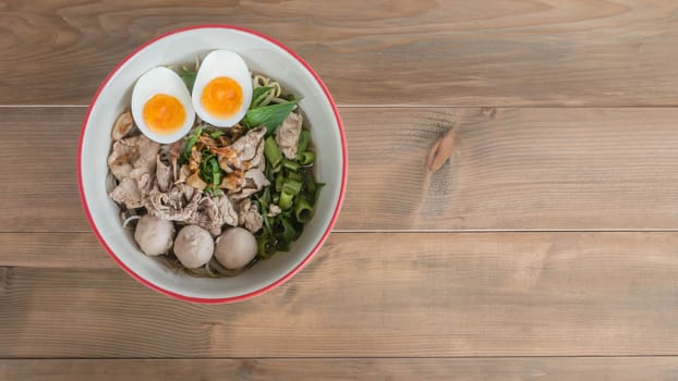 Asian white noodles with pork and vegetables in bowl over wooden background,  , Free space for text