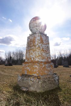 A lonely tombstone in an old cemetery.