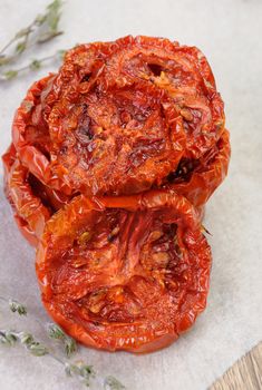 pile of dried tomatoes stacked on a baking paper with cumin and garlic