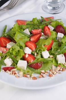 Salad of lettuce, arugula, strawberries, feta cheese and peanuts