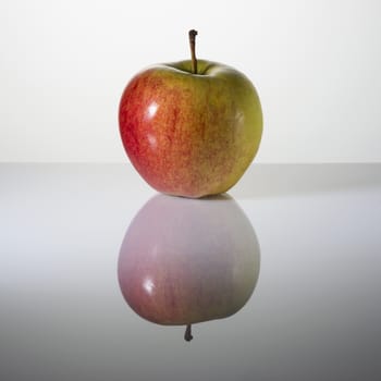 Beautiful elastic apple on a surface with reflection