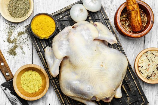 Raw chicken prepared for cooking and set of savory spices for meat