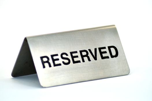 Plate of reservation of table of aluminum restaurant on white bottom.