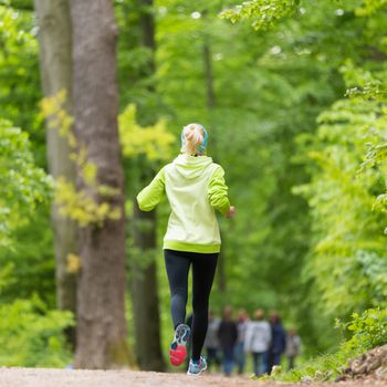 Sporty young female runner in forest.  Running woman. Female runner during outdoor workout in nature. Fitness model outdoors. Weight Loss. Healthy lifestyle. 