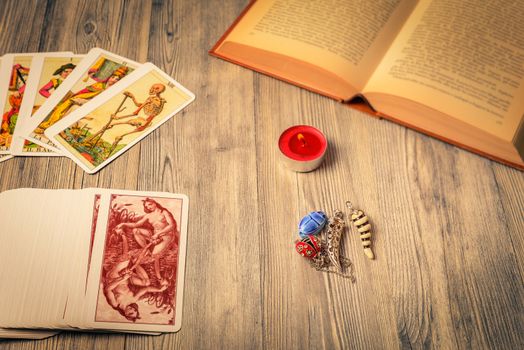 Composition of esoteric objects,candle,Tarots and book used for healing and fortune-telling,vintage style.