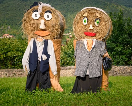 Pretty farmer Puppets(straw dolls) made out of Hay Bale with typical peasant clothes in europe autumn.