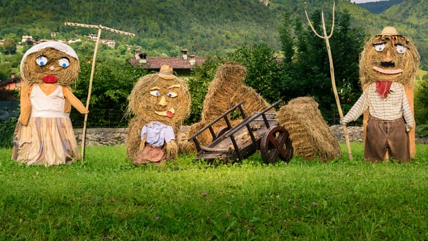 Lovely farmers family  Puppets(straw dolls) made out of Hay Bale with typical peasant clothes in europe autumn,square photo.