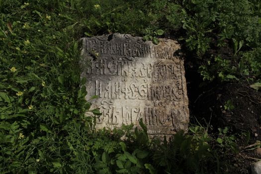 fragment of ancient gravestone inscription in the ancient language close to