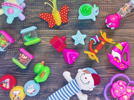 top view or flat lay on colorful toys on dark wooden background. Retro vintage filtered