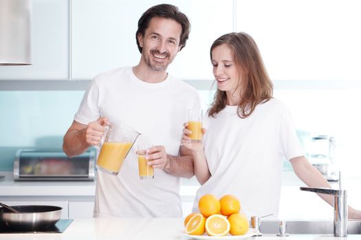 Couple with orange juice in the kitchen