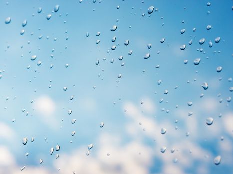 Water drops of rain on blue glass background. Rain drops on window. Shallow DOF.