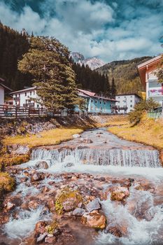 mountain river flowing through village in the Alps