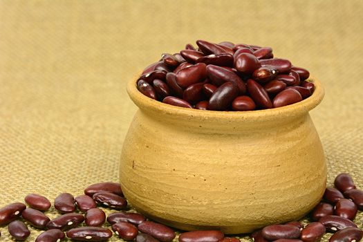 Dry red kidney beans in clay pot and on sackcloth