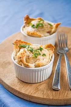 two servings of baked eggs on a wooden board.