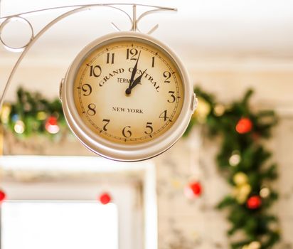 antique clock on the background of Christmas garlands.