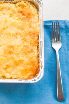 casserole in a disposable form of foil on a blue napkin