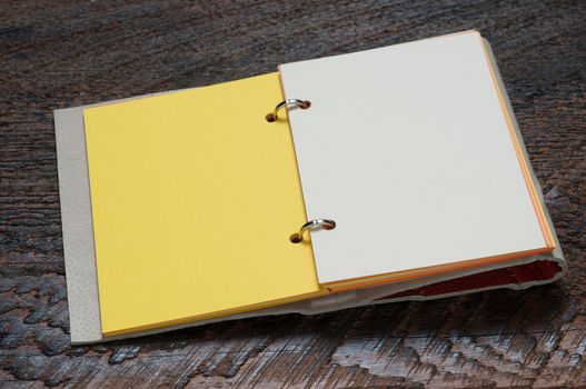 Open Notebook with yellow page on wooden background