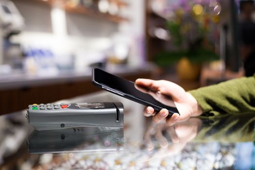 Woman paying on mobile phone by NFC