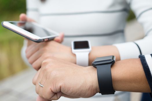 Two people using smartwatch together and connecting to cellphone