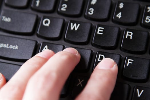 Fingers on a black keyboard, closeup photo