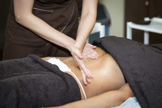 Massaging of young woman in SPA