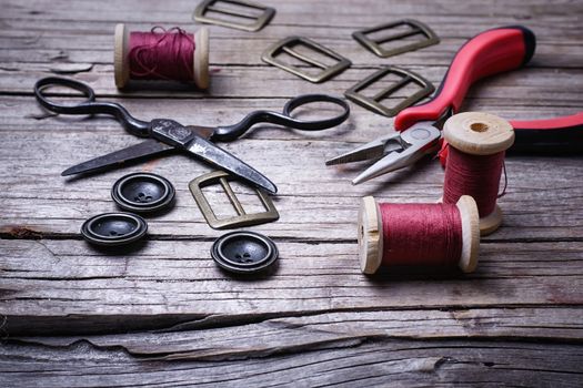 Buttons and fasteners from outdated clothes on wooden background