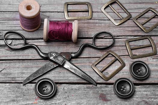 Buttons and fasteners from outdated clothes on wooden background