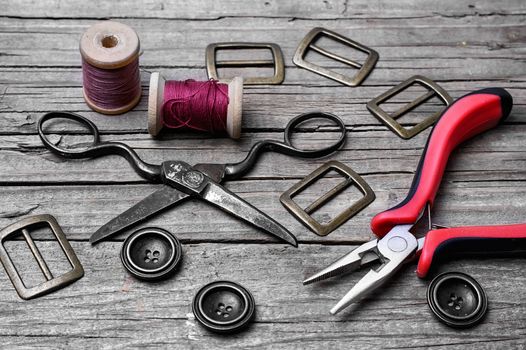 Buttons and fasteners from outdated clothes on wooden background