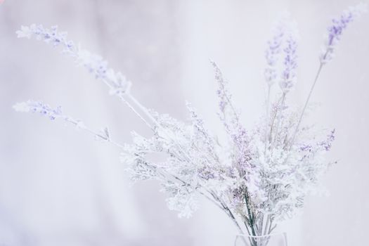 Soft purple vintage florals in clear glass vase, selective focus.