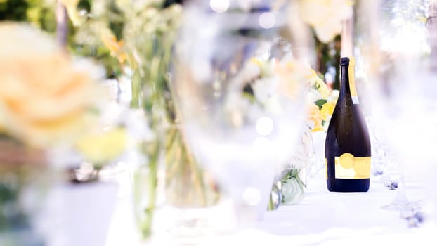champagne on elegance table set up white, green and yellow flowers theme, selective focus.