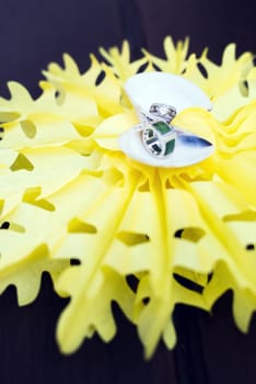 Wedding rings put in shell on yellow star background.