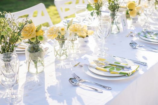 Elegance table set up white, green and yellow flowers theme, selective focus.