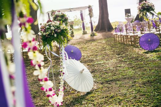 Beach wedding ceremony setup with white/purple colours theme, selective focus.