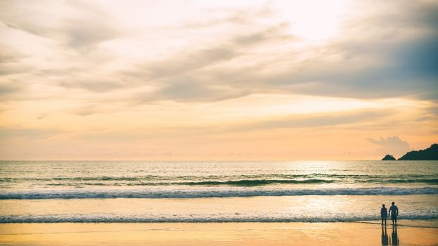 Couples on wide beaches at romantic sunset time.