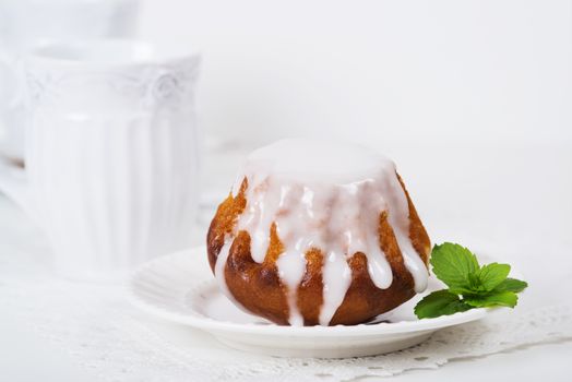 Rum baba cake on plate on light background