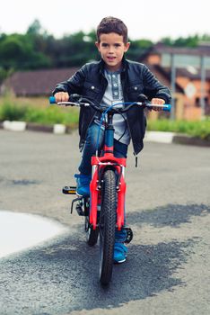 Cute boy riding bike in a city