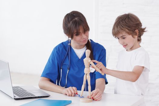 Doctor explain medicine to child using wooden doll