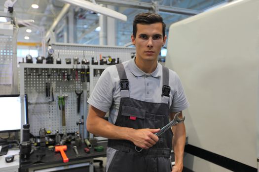 Worker at workplace with computer and tools at CNC factory