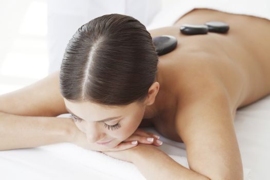 Girl on a stone therapy, hot stone massage