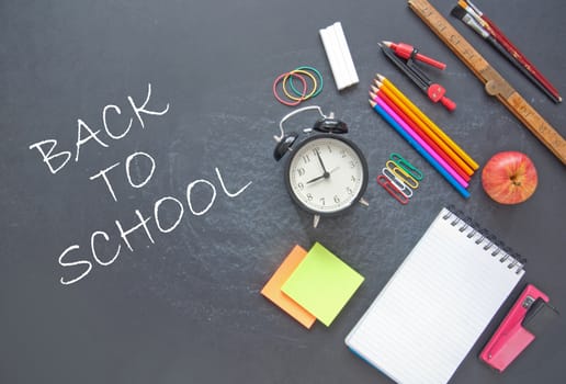 Back to school written on a chalkboad with stationery accessories